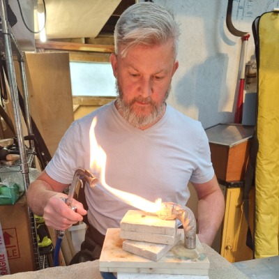 Silversmith working with a silversmith blow torch