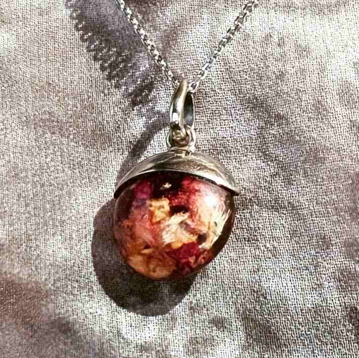 Crushed Dried Wedding Flowers set in a resin orb with an elegant white gold silver pendant setting